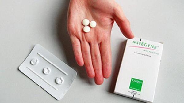 Hand holding RU486 abortion drug tablets pills. medical pharmaceuticals drugs RU-486 packaging