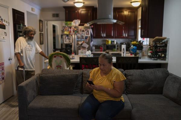 Ana Sandoval, Evin Hernandez's mother checks her phone while talking to Hernandez's father, Pedro Martinez,