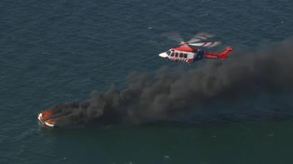 Two people have been rescued after a boat burst into flames in Melbourne<em></em>’s Port Phillip Bay sending black plumes of smoke into the sky. Picture: Nine