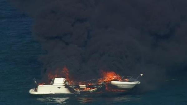 Two people have been rescued after a boat burst into flames in Melbourne<em></em>’s Port Phillip Bay sending black plumes of smoke into the sky. Picture: Nine