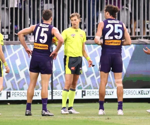 Sport. AFL. Fremantle Dockers v North Melbourne at Optus Stadium in Perth. Umpire Robert Findlay speaks to a fellow umire after calling full time while Dockers players Ethan Hughes and Alex Pearce watch on. 